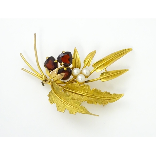 584 - A 9ct gold brooch of foliate form set with garnets and pearls. Approx. 2