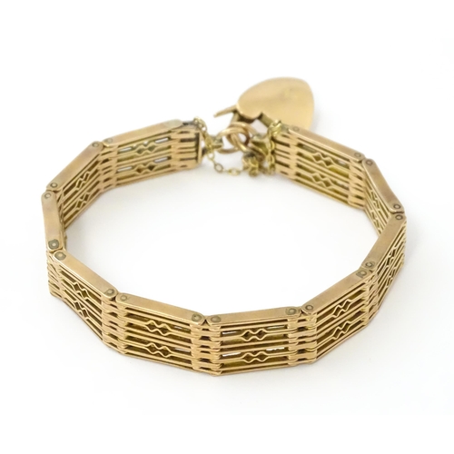 585 - A 9ct gold and yellow metal bracelet with padlock style clasp. Approx. 7