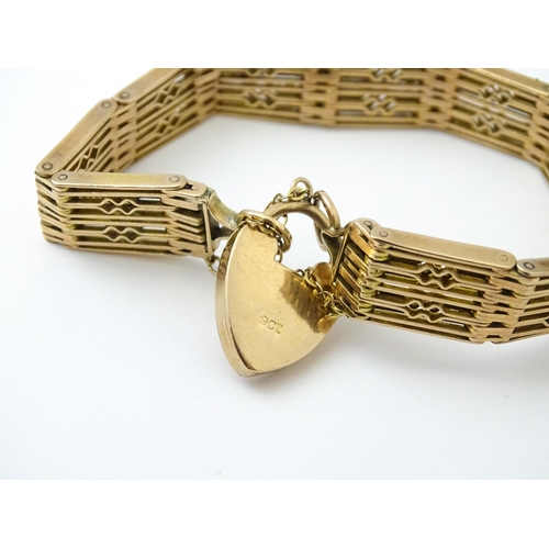 585 - A 9ct gold and yellow metal bracelet with padlock style clasp. Approx. 7