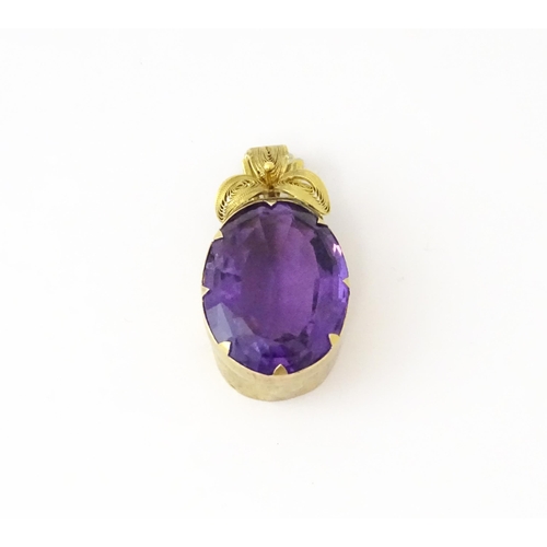 587 - A yellow metal pendant set with central amethyst, and filigree style floral detail. Approx. 1