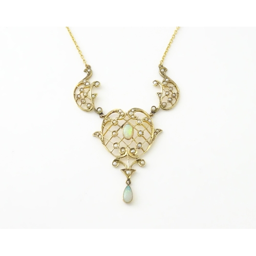 588 - A 9ct gold Art Nouveau necklace the pendant set with seed pearls and opals. On later yellow metal ch... 