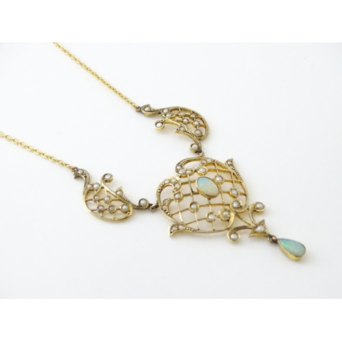 588 - A 9ct gold Art Nouveau necklace the pendant set with seed pearls and opals. On later yellow metal ch... 