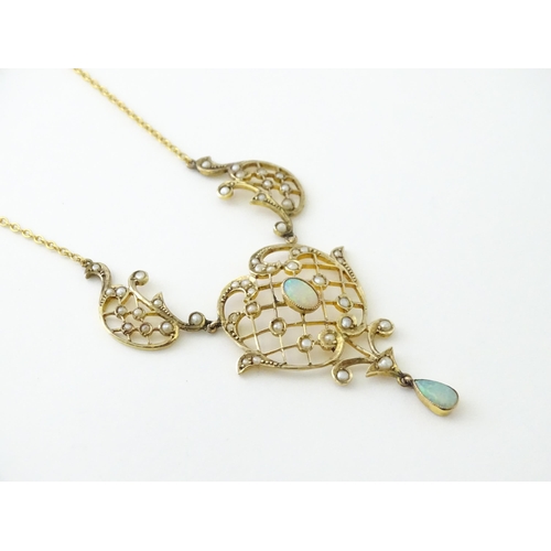 588 - A 9ct gold Art Nouveau necklace the pendant set with seed pearls and opals. On later yellow metal ch... 