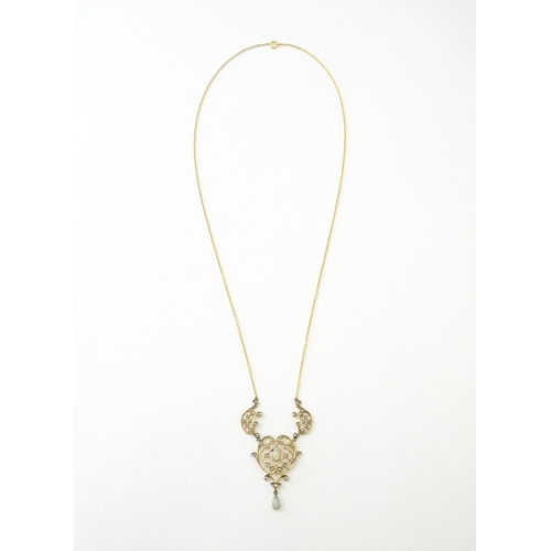 588 - A 9ct gold Art Nouveau necklace the pendant set with seed pearls and opals. On later yellow metal ch... 