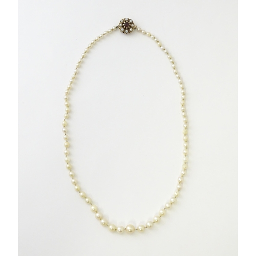 589 - A graduated pearl necklace with a 9ct gold clasp set with pearls and garnet. Approx. 17