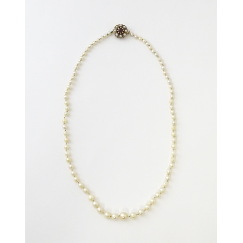 589 - A graduated pearl necklace with a 9ct gold clasp set with pearls and garnet. Approx. 17