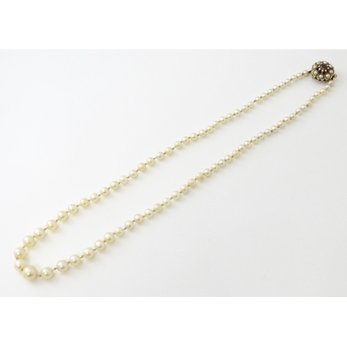 589 - A graduated pearl necklace with a 9ct gold clasp set with pearls and garnet. Approx. 17