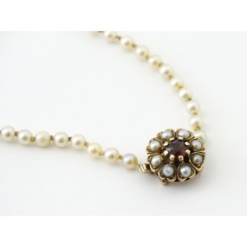 589 - A graduated pearl necklace with a 9ct gold clasp set with pearls and garnet. Approx. 17