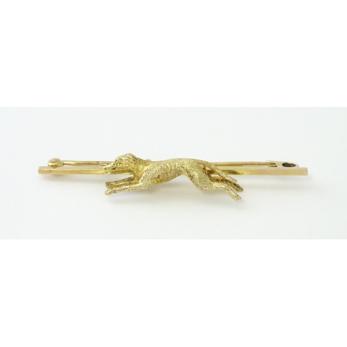 590 - A 9ct gold bar brooch with greyhound / dog detail. Approx. 2 1/4