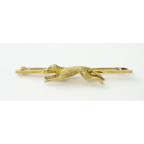 590 - A 9ct gold bar brooch with greyhound / dog detail. Approx. 2 1/4