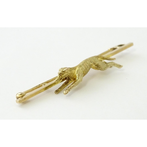 590 - A 9ct gold bar brooch with greyhound / dog detail. Approx. 2 1/4