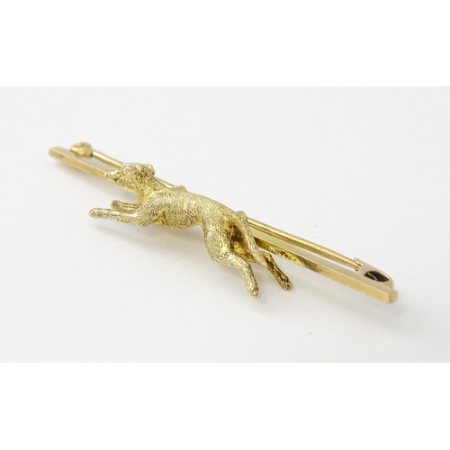 590 - A 9ct gold bar brooch with greyhound / dog detail. Approx. 2 1/4