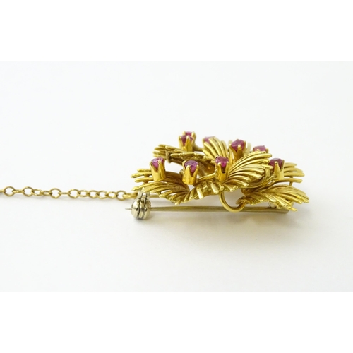 591 - An 18ct gold brooch / pendant of stylised floral form set with 9 rubies. Approx. 1 1/4