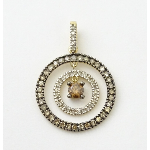 598 - A 14ct gold pendant of concentric circle form set with diamonds and having a central brown coloured ... 