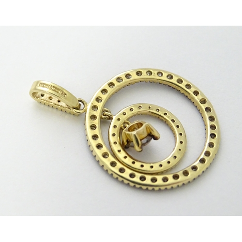 598 - A 14ct gold pendant of concentric circle form set with diamonds and having a central brown coloured ... 