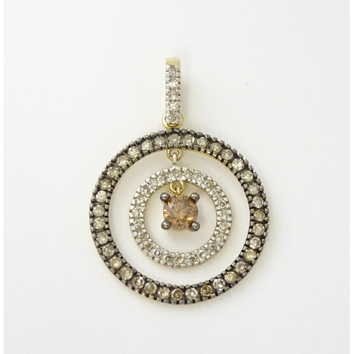 598 - A 14ct gold pendant of concentric circle form set with diamonds and having a central brown coloured ... 