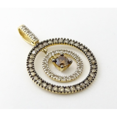 598 - A 14ct gold pendant of concentric circle form set with diamonds and having a central brown coloured ... 