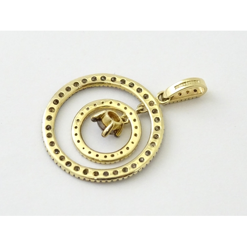 598 - A 14ct gold pendant of concentric circle form set with diamonds and having a central brown coloured ... 