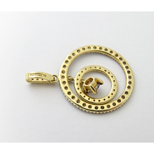 598 - A 14ct gold pendant of concentric circle form set with diamonds and having a central brown coloured ... 