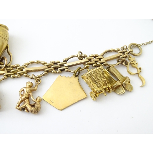 600 - A 9ct gold charm bracelet with padlock clasp, set with various charms, mostly 9ct gold to include te... 