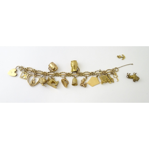 600 - A 9ct gold charm bracelet with padlock clasp, set with various charms, mostly 9ct gold to include te... 