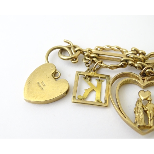 600 - A 9ct gold charm bracelet with padlock clasp, set with various charms, mostly 9ct gold to include te... 