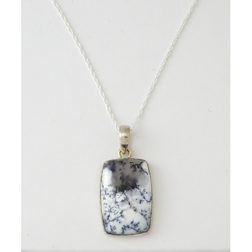 602 - A silver pendant set with dendrite agate with a silver chain. Pendant approx. 1 3/4