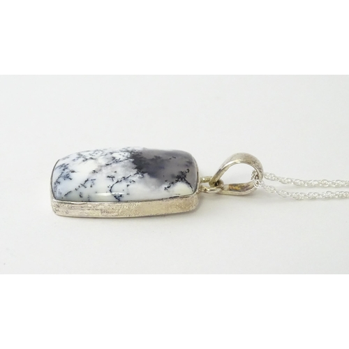 602 - A silver pendant set with dendrite agate with a silver chain. Pendant approx. 1 3/4