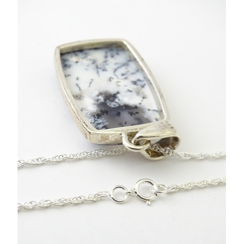 602 - A silver pendant set with dendrite agate with a silver chain. Pendant approx. 1 3/4