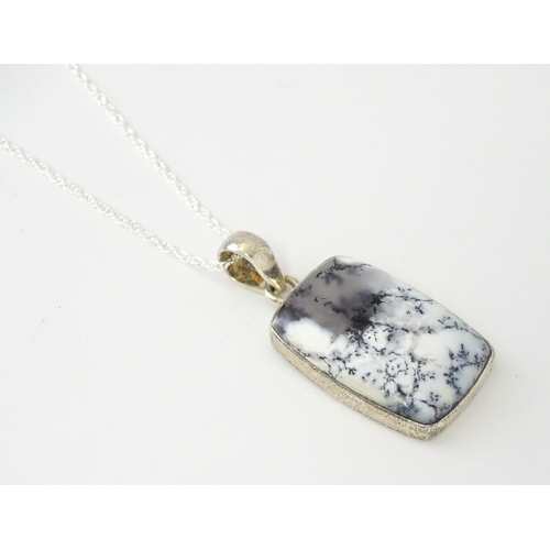 602 - A silver pendant set with dendrite agate with a silver chain. Pendant approx. 1 3/4