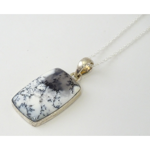 602 - A silver pendant set with dendrite agate with a silver chain. Pendant approx. 1 3/4