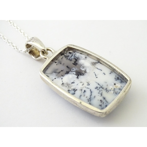 602 - A silver pendant set with dendrite agate with a silver chain. Pendant approx. 1 3/4