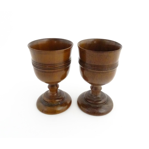 1163 - Treen : A pair of early 19thC fruitwood goblets with turned banded decoration. Approx. 4 3/4