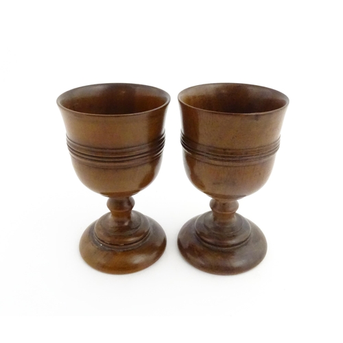 1163 - Treen : A pair of early 19thC fruitwood goblets with turned banded decoration. Approx. 4 3/4