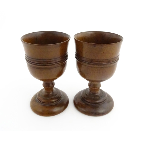 1163 - Treen : A pair of early 19thC fruitwood goblets with turned banded decoration. Approx. 4 3/4