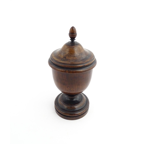 1166 - Treen : A 19thC turned wooden pedestal caddy of urn form with acorn finial. Approx. 9 1/4