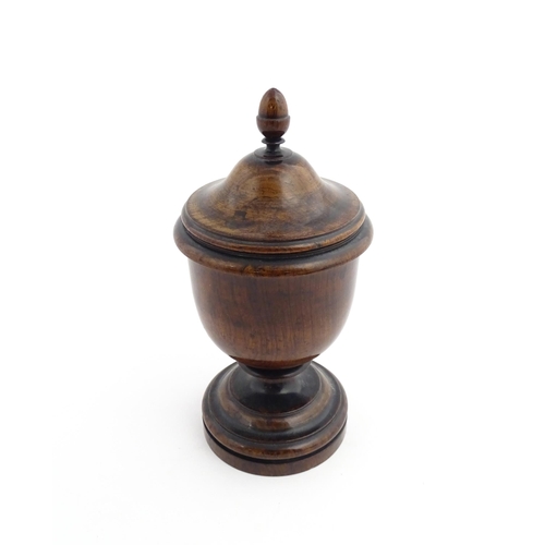 1166 - Treen : A 19thC turned wooden pedestal caddy of urn form with acorn finial. Approx. 9 1/4