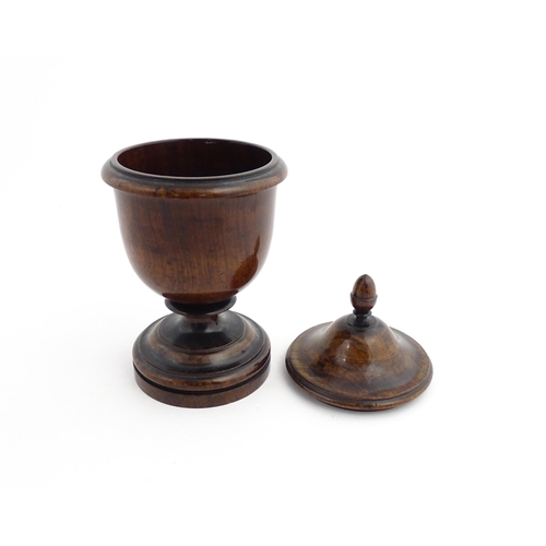 1166 - Treen : A 19thC turned wooden pedestal caddy of urn form with acorn finial. Approx. 9 1/4