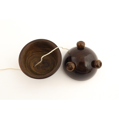 1168 - Treen : A 19thC lignum vitae string box of circular form raised on three feet. Approx. 3