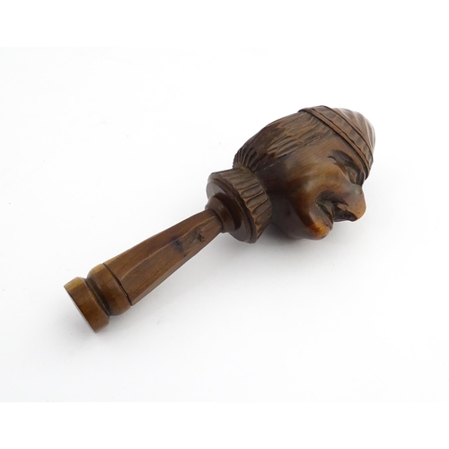 1172 - Treen : A 19thC Continental carved walnut nutcracker with figural head decoration. Approx. 5 3/4