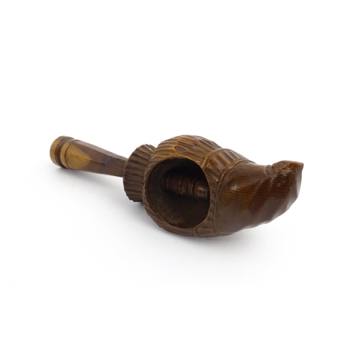 1172 - Treen : A 19thC Continental carved walnut nutcracker with figural head decoration. Approx. 5 3/4