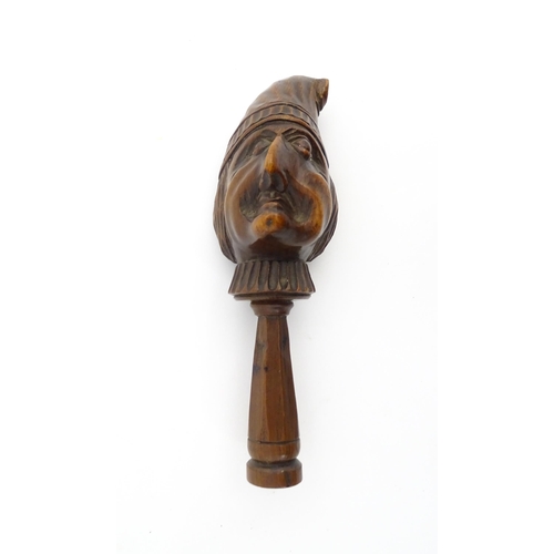 1172 - Treen : A 19thC Continental carved walnut nutcracker with figural head decoration. Approx. 5 3/4