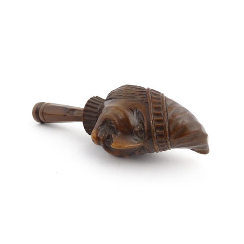 1172 - Treen : A 19thC Continental carved walnut nutcracker with figural head decoration. Approx. 5 3/4