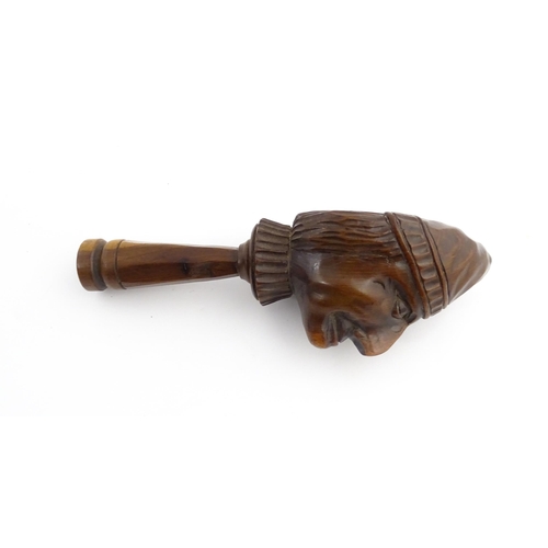 1172 - Treen : A 19thC Continental carved walnut nutcracker with figural head decoration. Approx. 5 3/4