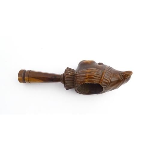 1172 - Treen : A 19thC Continental carved walnut nutcracker with figural head decoration. Approx. 5 3/4