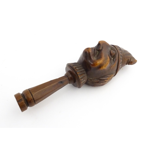 1172 - Treen : A 19thC Continental carved walnut nutcracker with figural head decoration. Approx. 5 3/4