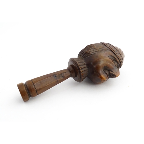 1172 - Treen : A 19thC Continental carved walnut nutcracker with figural head decoration. Approx. 5 3/4