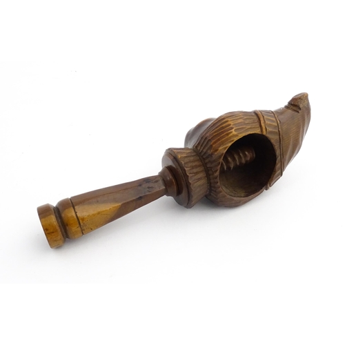 1172 - Treen : A 19thC Continental carved walnut nutcracker with figural head decoration. Approx. 5 3/4