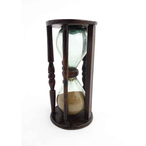 1185 - Treen : A 19thC sand timer, the wooden frame with turned uprights. Approx. 7 3/4