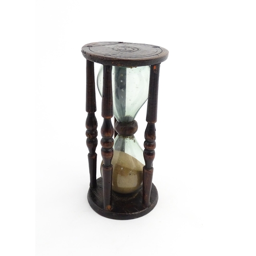 1185 - Treen : A 19thC sand timer, the wooden frame with turned uprights. Approx. 7 3/4